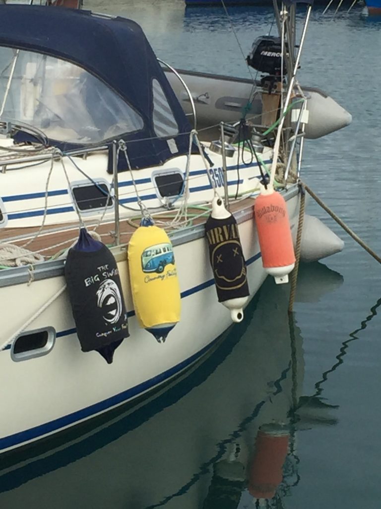 4 fenders on the side of a boat covered in homemade t-shirt covers
